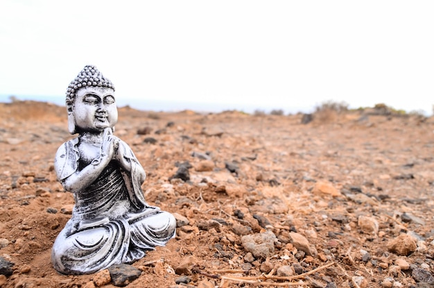 Een oud Boeddhabeeld verlaten in de woestijn