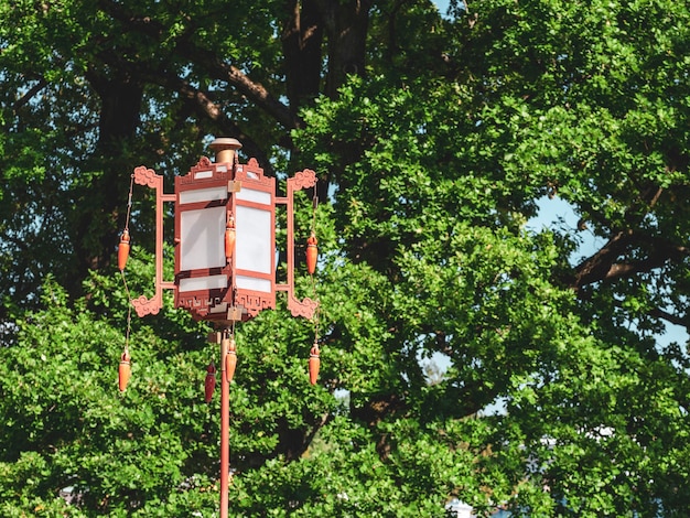 Een oude Chinese lantaarn op een groene boom.