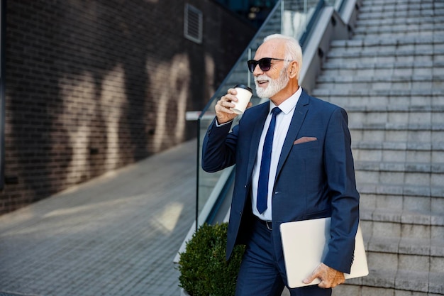 Een oude directeur loopt het zakencentrum binnen en drinkt koffie