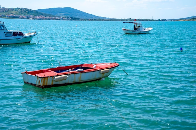 Een oude en kleine vissersboot op de achtergrond van een Turkse stad op een zomerse en zonnige dag