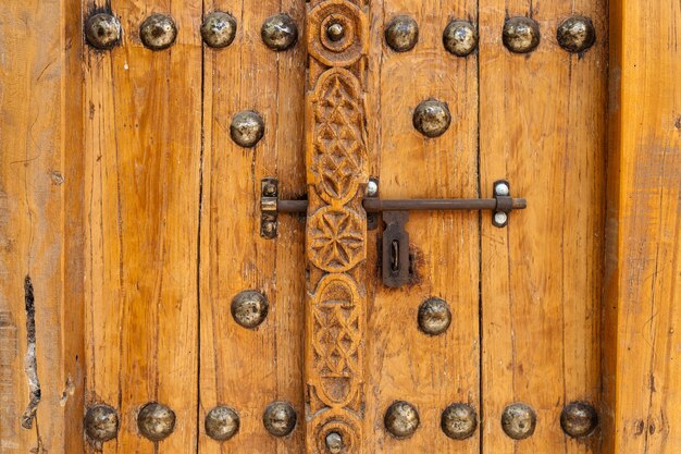 Een oude houten deur met metalen klink, gesloten, close-up, Unaited Arabische Emiraten