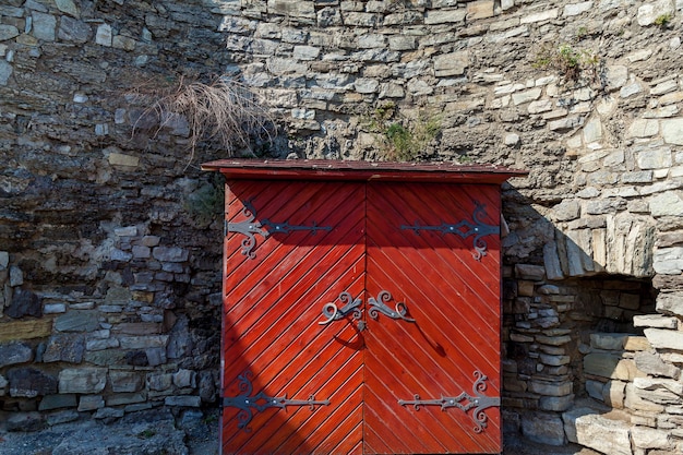 Foto een oude houten kast met gesmede elementen op de achtergrond van een grijze muur van kasteel kamianets-podilskyi.