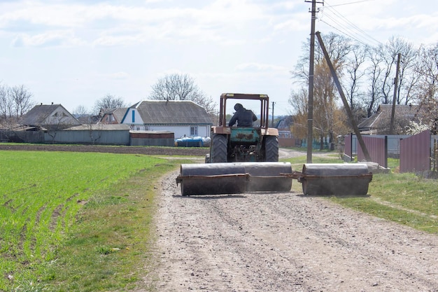 Foto een oude tractor die metalen rollen draagt om gewassen op het veld te rollen