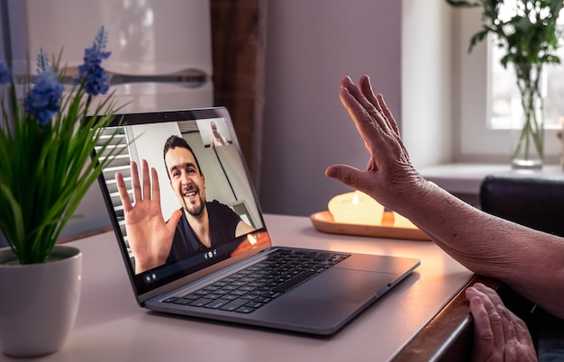 Foto een oude vrouw communiceert met haar zoon via een videoverbinding via een laptop