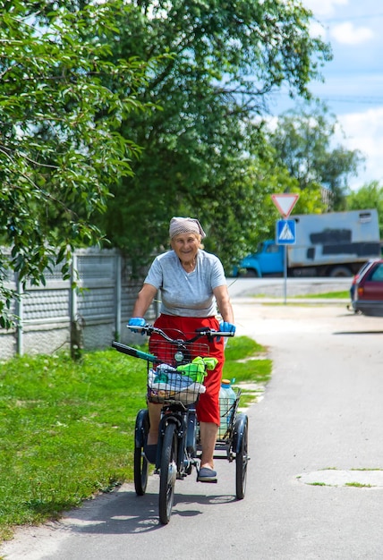 Een oude vrouw rijdt op een fiets Selectie focus