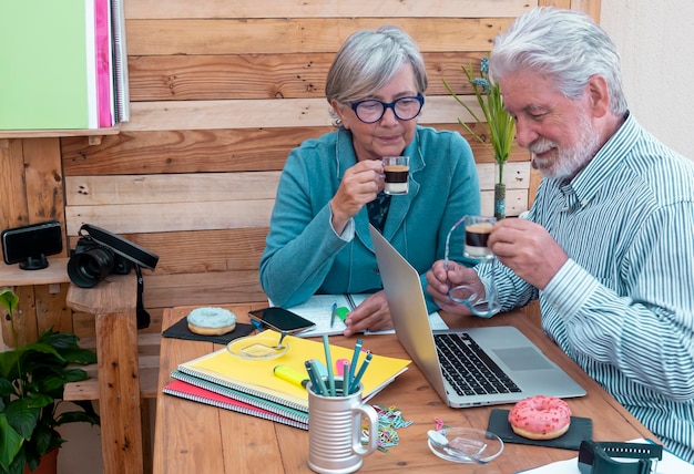 Foto een ouder echtpaar houdt koffie vast terwijl ze aan tafel zitten