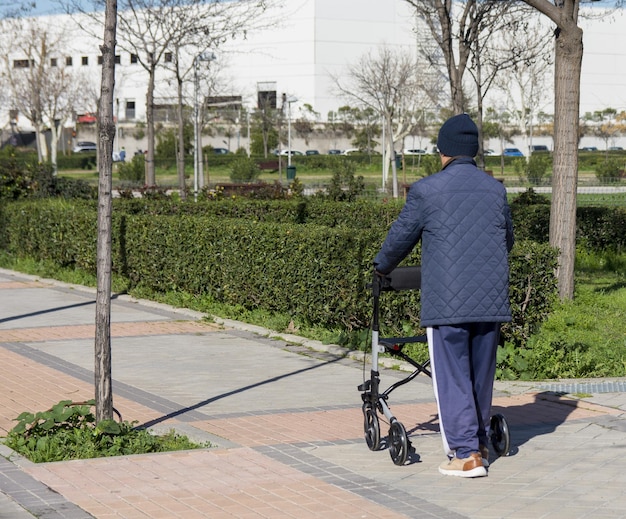 Een oudere man die een wandelstoel gebruikt op straat