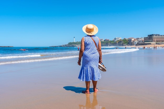 Een oudere vrouw die op het strand loopt in de badplaats Biarritz Lapurdi France South West