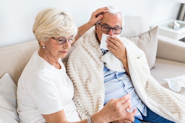 Een oudere vrouw helpt een zieke echtgenoot