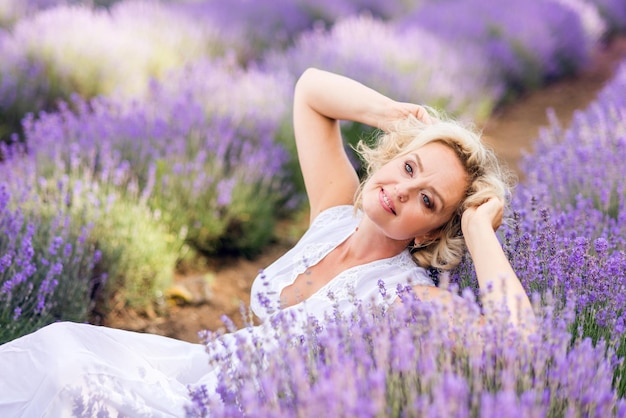 Een oudere vrouw in een lavendelveld mooie senior geniet van bloemen