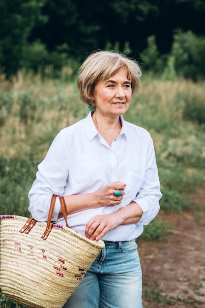 Een oudere vrouw loopt in het zomerpark