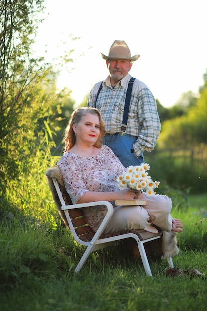 Een oudere vrouw met een avondmake-up op de veranda van een landhuis