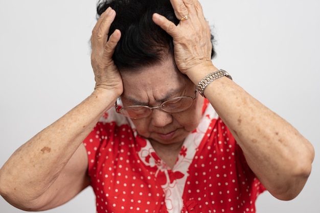 Een oudere vrouw met ernstige hoofdpijn lijdt aan een beroerte of hersenziekte. Patiënt houdt het hoofd vast.