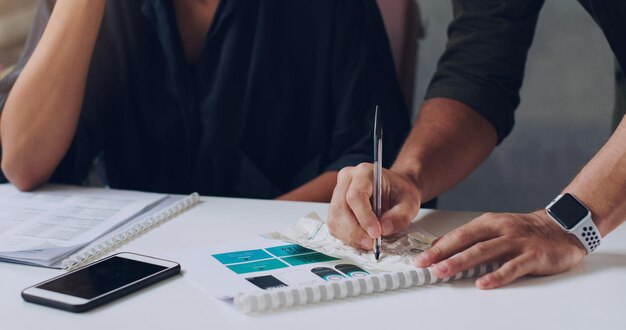 Een paar aantekeningen maken Bijgesneden opname van twee onherkenbare zakenmensen die samenwerken op kantoor