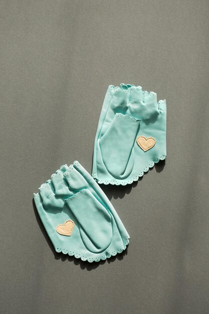 Een paar blauwe leren handschoenen met een wit hart op de handpalm