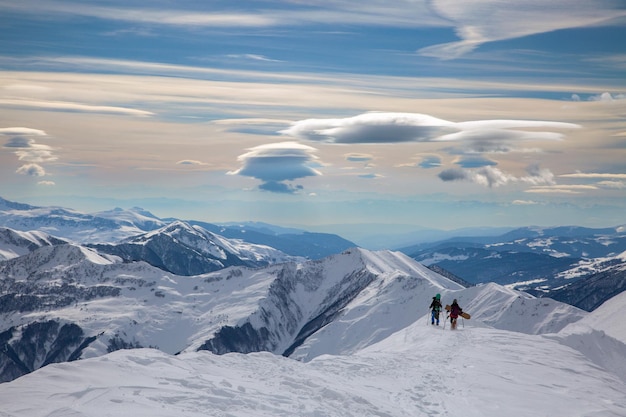 Een paar freeriders beklimmen de bergen tegen een spectaculaire lucht in Gudauri Caucasus Georgia