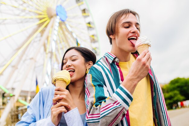 Een paar geliefden daten in een pretpark en ijsjes eten