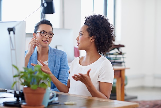 Een paar geweldige ideeën bedenken Shot van twee collega's die een discussie hebben op een computer op kantoor