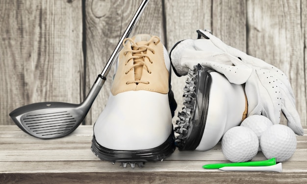 Foto een paar golfschoenen en een golfclub op achtergrond