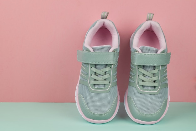 Een paar grijze modieuze sneakers op blauw en roze