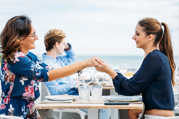 Foto een paar handen van de vrouwenholding terwijl het bekijken elkaar glimlachend bij een restaurantlijst