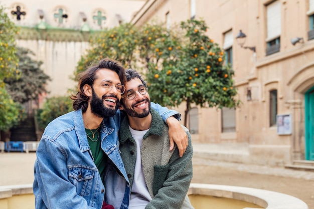 Een paar homoseksuele mannen glimlachend gelukkig zittend in een park