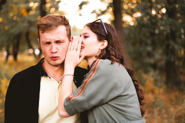 Een paar jonge mannen en vrouwen vertellen elkaar het geheim, fluisteren in het oor