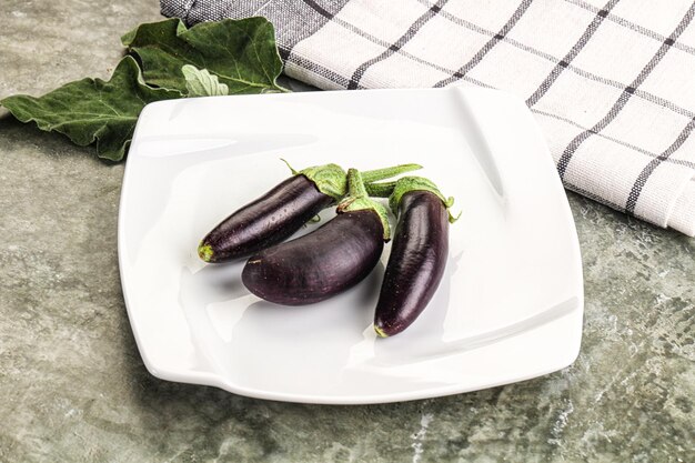 Een paar kleine baby aubergines aan boord.