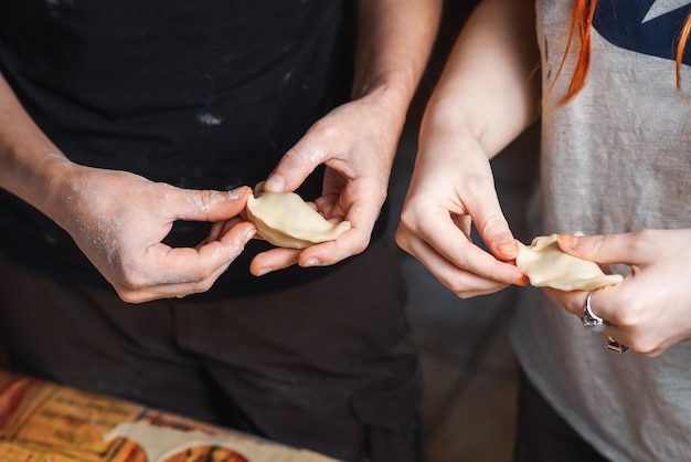 Een paar lesbische vrouwen zijn bezig met het koken van knoedels in de keuken Onherkenbare vrouwelijke handen beeldhouwen knoedels