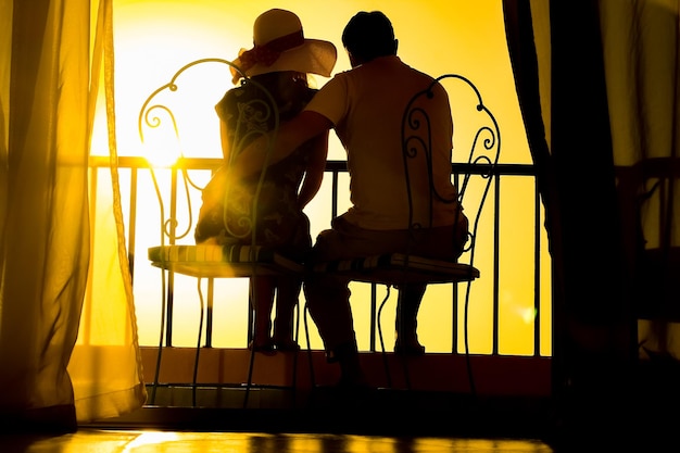 Een paar man en vrouw silhouet op een balkon aan zee op de achtergrond Ontmoeting in een dubbele date op het terras