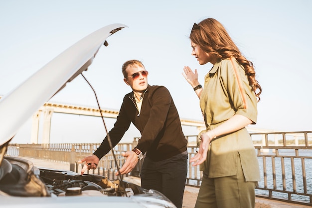 Een paar mannen en vrouwen hebben wat autoproblemen tijdens het reizen, reparatie motorcontrole engine