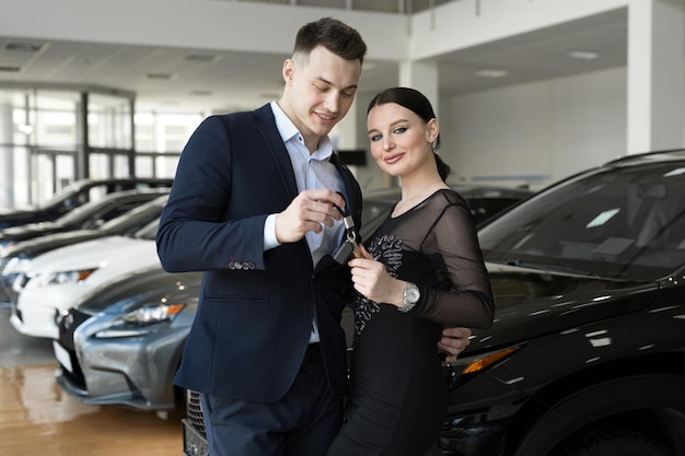 Een paar mannen en vrouwen kopen graag een nieuwe auto bij een autodealer