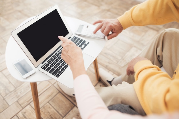 Een paar oude mensen zitten voor een laptop