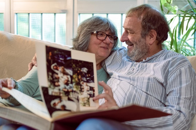 Foto een paar oudere koppels die herinneringen ophalen aan hun vroegere gelukkige senioren die samen naar hun trouwboek kijken