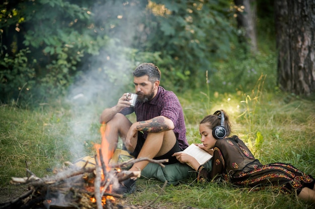 Een paar reizigers ontspannen bij een kampvuur in het bos