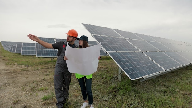 Een paar specialisten die samenwerken, controleren en leren het rapport van investeringen voor duidelijke energieproductie. concept van groene energie. groen energieconcept. zonnepaneel veld.