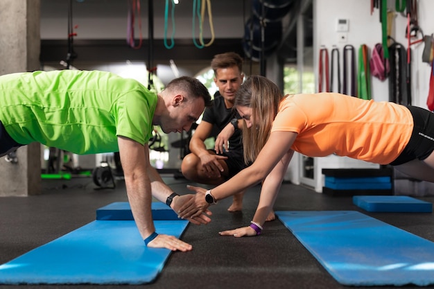 Een paar stagiaires geven highfives als oefening in de sportschool