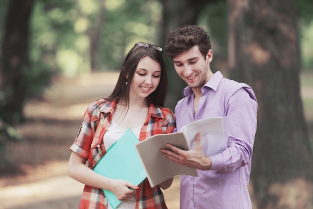 Een paar studenten bespreken hun records terwijl ze in het park staan