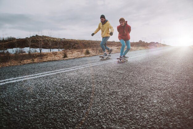 Een paar tieners plezier schaatsen en bergafwaarts maken