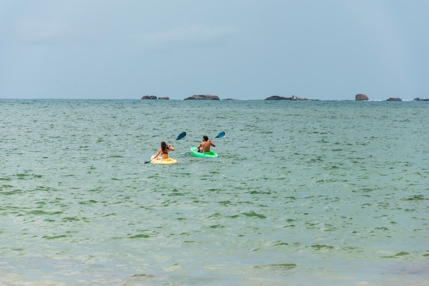 Een paar zwemt in een kajak of kano in de zee of de oceaan. Kajakken of kanovaren concept met mensen. Ruimte voor tekst