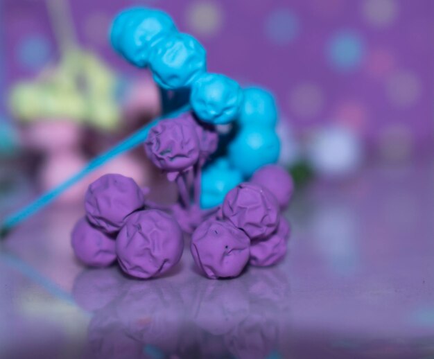 Foto een paarse en blauwe snoepstok staat op een tafel met andere snoepjes.