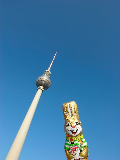 Een paashaas van chocolade poseert met de Berliner TV-toren voor een strakblauwe lucht