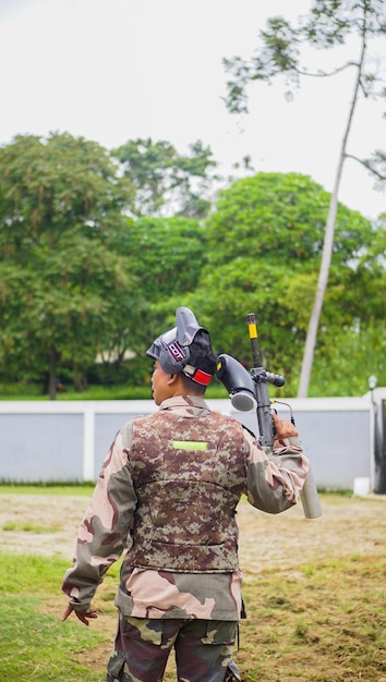 Foto een paintballspeler die een pistool droeg