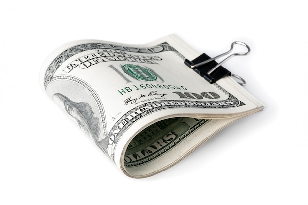 Een pak Amerikaanse honderd-dollarbiljetten in tweeën gevouwen en vastgemaakt met een klerikale gesp.