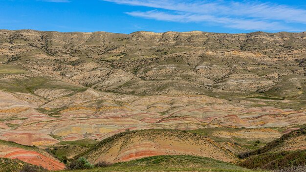 Een panoramisch uitzicht op een kleurrijk geërodeerd berglandschap dat mogelijk een geologische formatie weergeeft