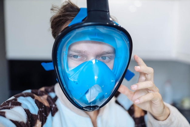 een paranoïde man met een medisch masker zet een snorkelmasker op ter bescherming tegen het virus