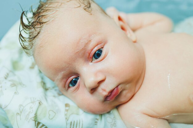 Een pasgeboren baby baden in een badkuip Het eerste bad van een pasgeboren baby