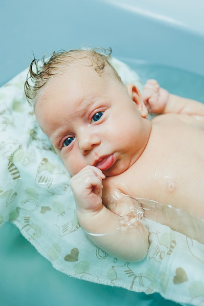 Een pasgeboren baby baden in een badkuip Het eerste bad van een pasgeboren baby