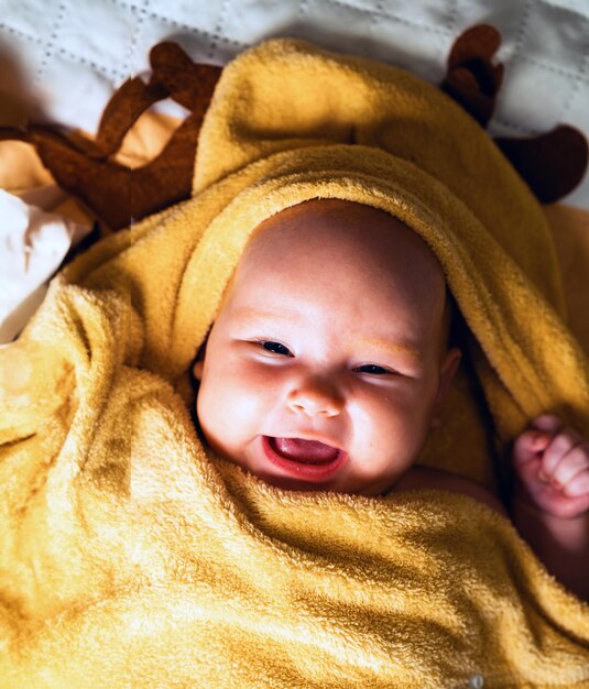 Een pasgeboren baby gewikkeld in een handdoek na het baden het concept van kindertijd en kinderzorg