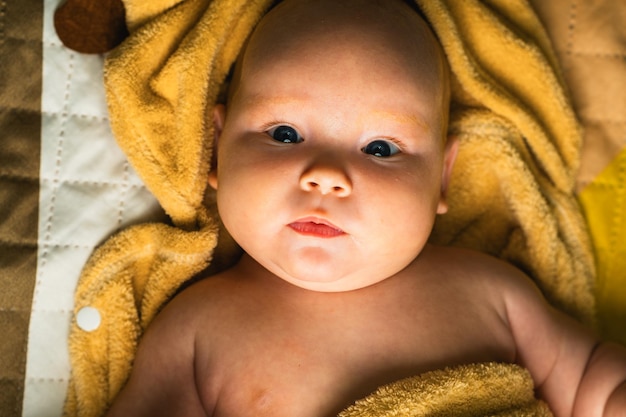 Een pasgeboren baby in een handdoek gewikkeld na het baden Het concept van kinder- en zuigelingenzorg